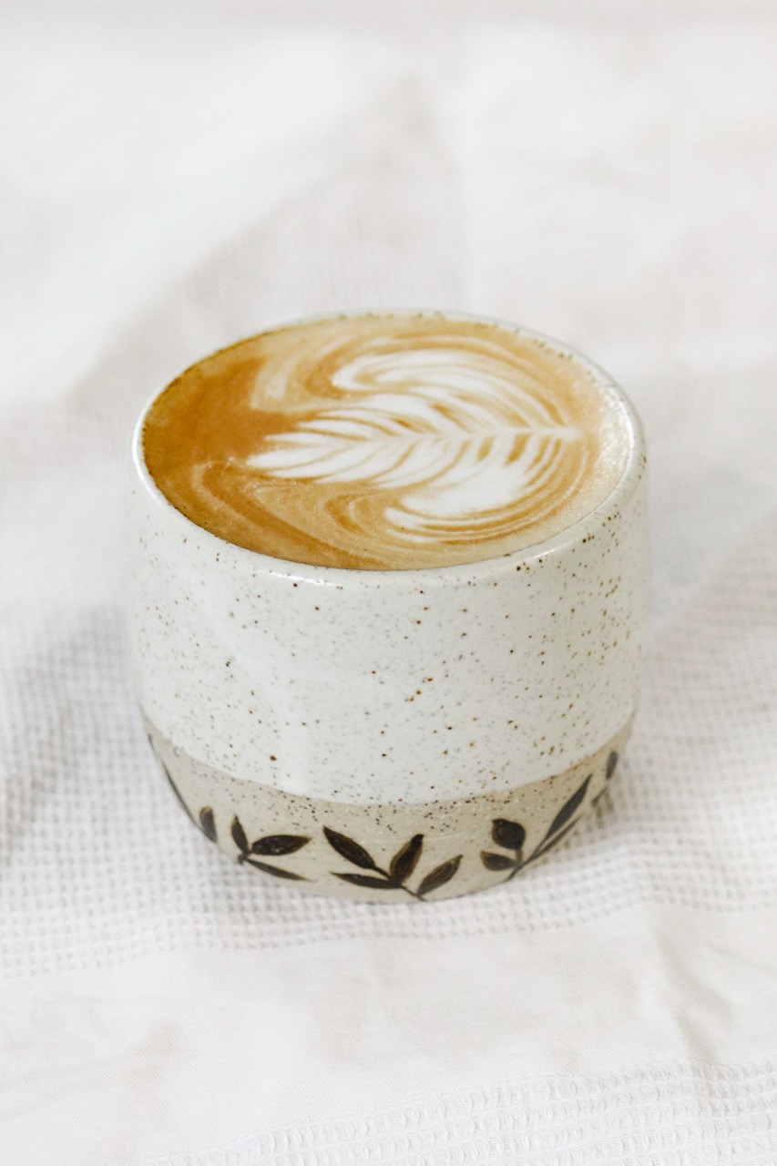 Handcrafted coffee cup with leaf motifs