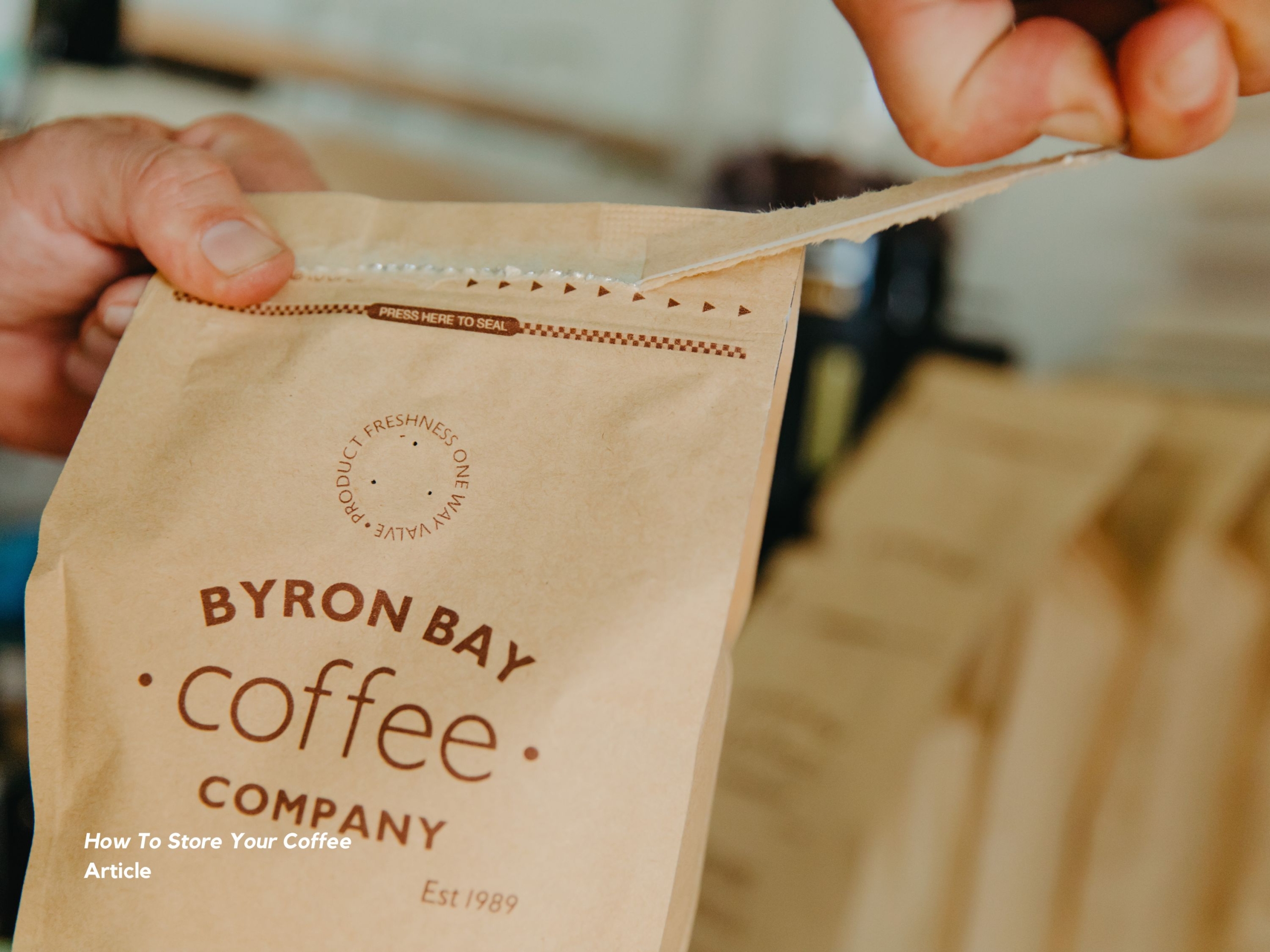 Hand opening the seal of a coffee bag